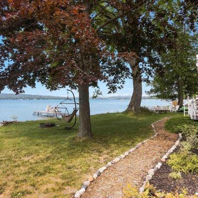 Lake side of cottage with stone lined path 